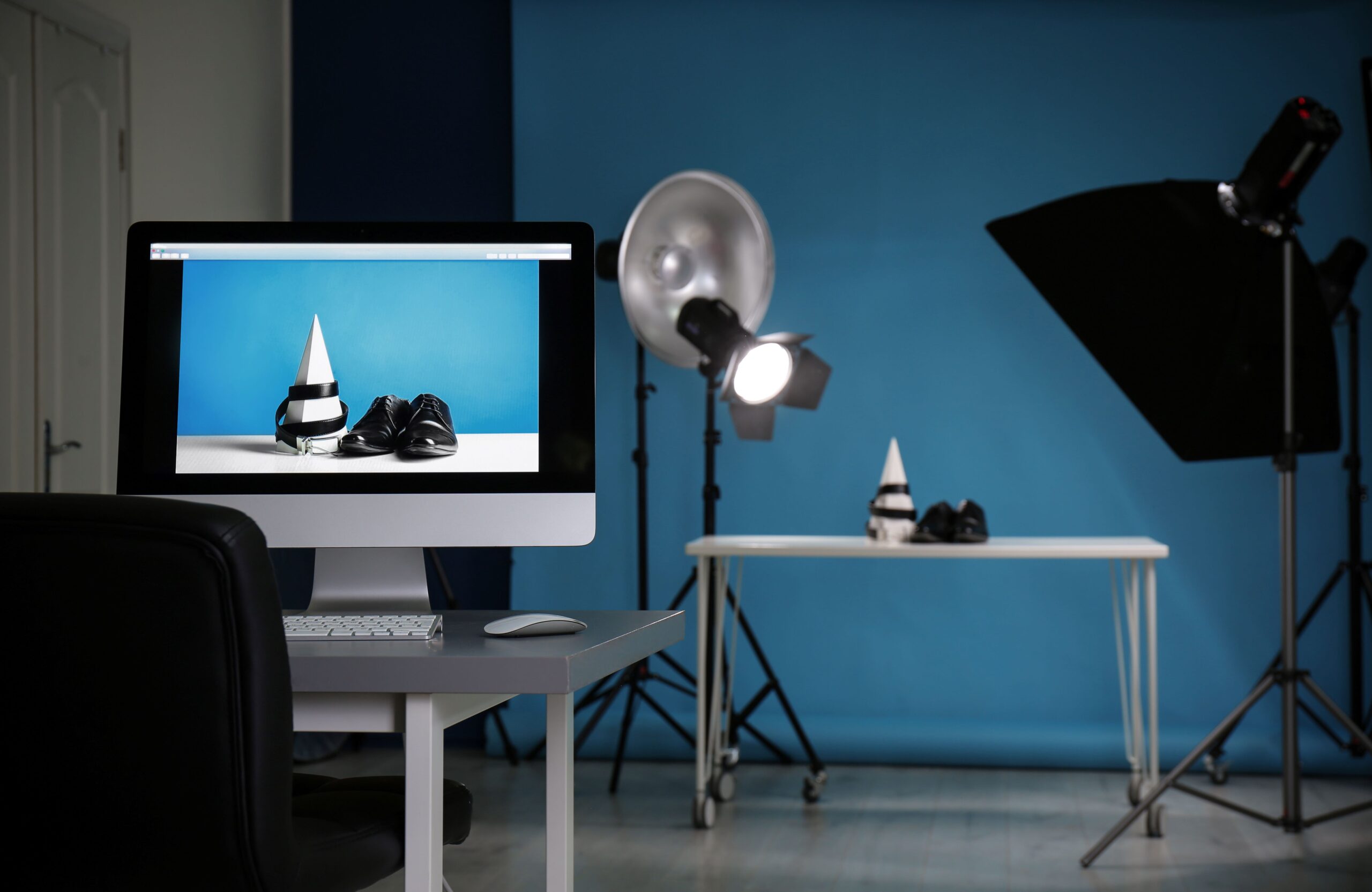 Aufnahme von Herrenschuhen und Gürtel zur Produktwerbung im Fotostudio, Fokus auf PC-Bildschirm