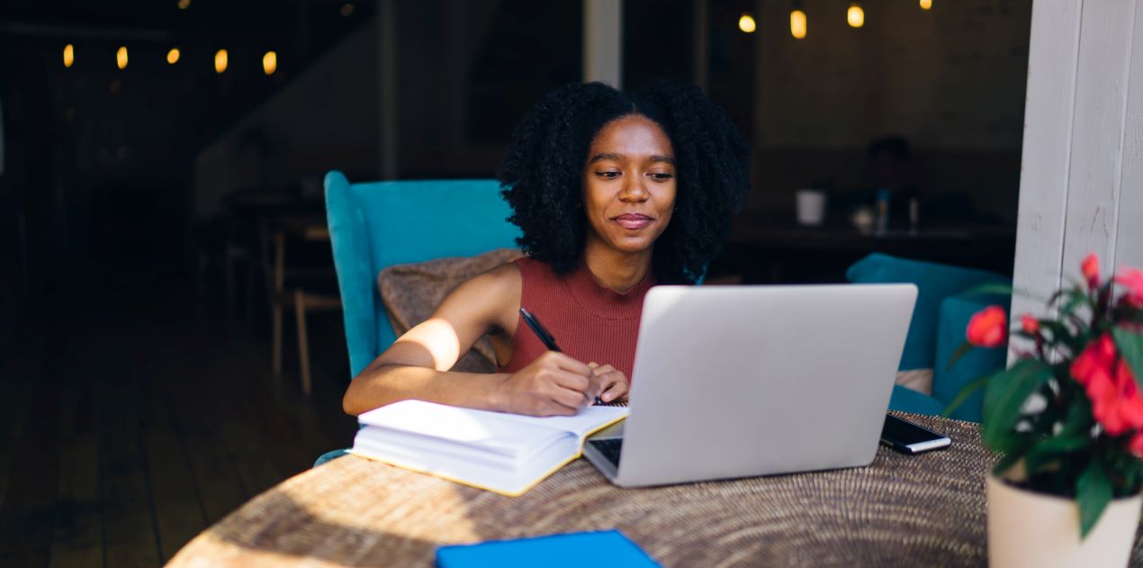 Frau, die an einem Laptop in einer gemütlichen Umgebung arbeitet und E-Learning Content nutzt