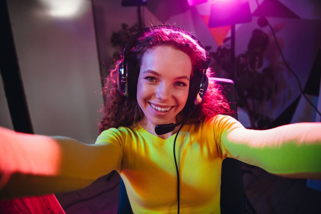 Lachende Streamerin mit Locken macht Selfie im Studio – gepflegter Look durch schnelle Routine und laserhaarentfernung dauerhaft für Gesicht und Achseln