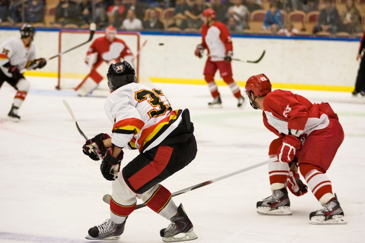 Eishockeyspieler im Spiel auf dem Eis, ausgestattet mit Bauer Schlittschuhen und kompletter Schutzausruestung